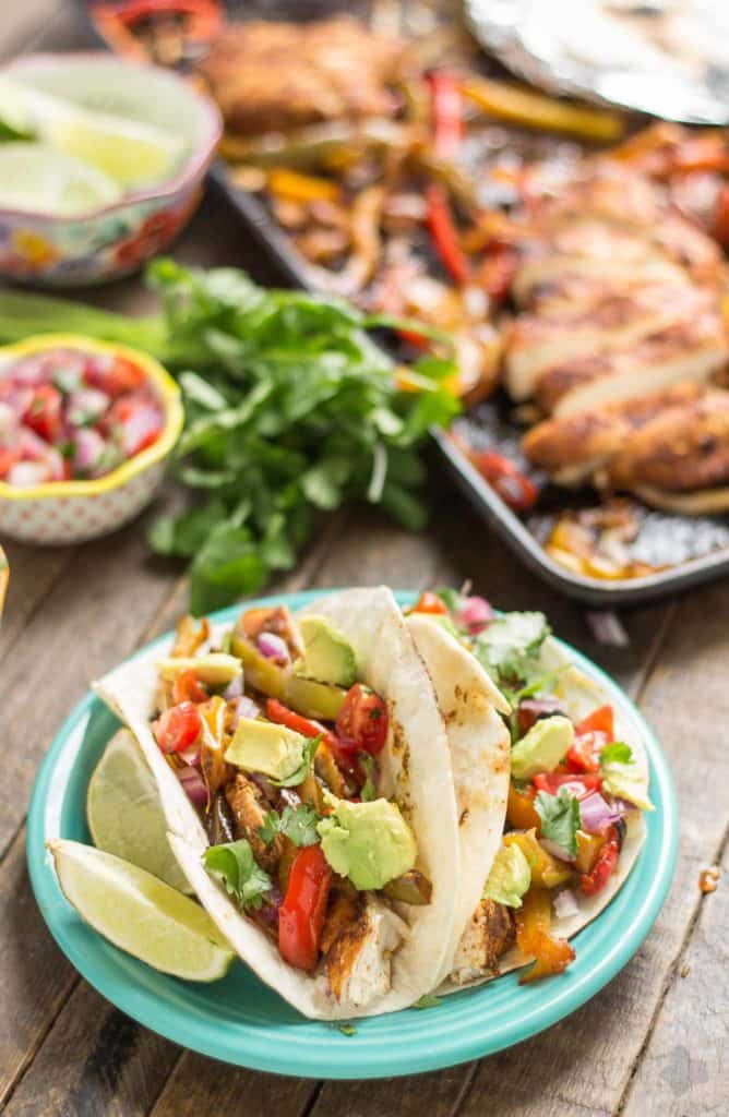 Bursting with flavor and cooked all on ONE pan, these easy Sheet Pan Chicken Fajitas are sure to become permanent in your dinner rotation. You'll love the quick cleanup too! | Strawberry Blondie Kitchen