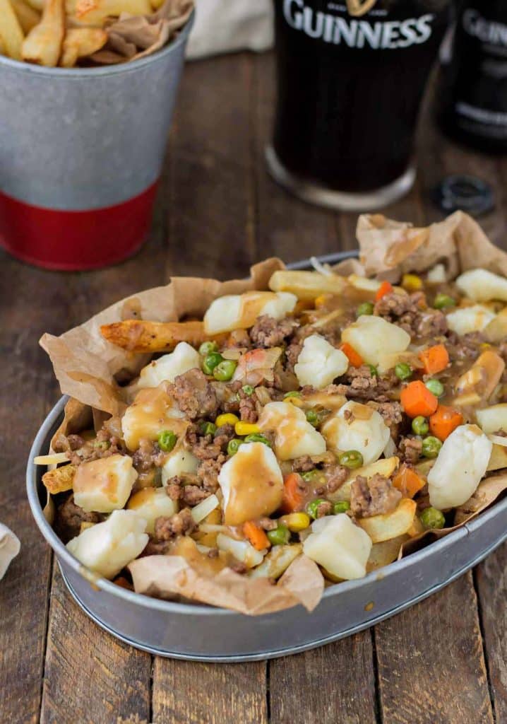 Crispy fries piled high with beef and mixed vegetables, smothered in Guinness gravy and topped with cheese curds make for one awesome Shepherd's Pie Poutine. | Strawberry Blondie Kitchen