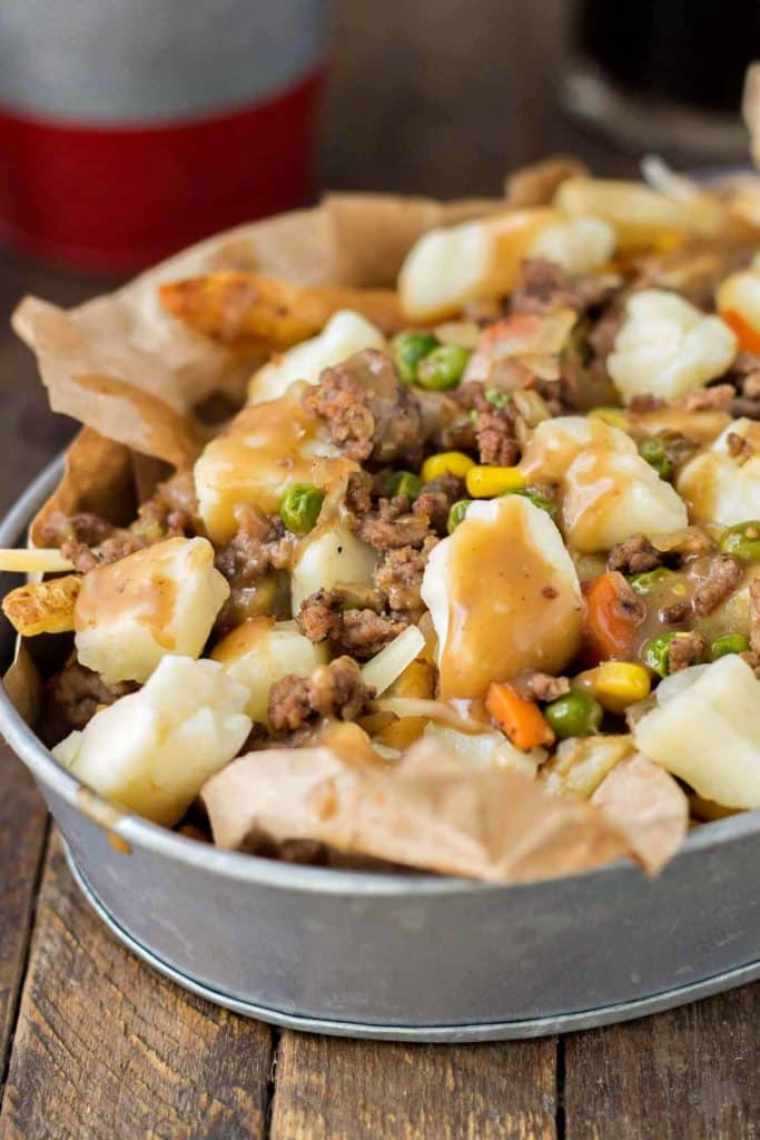 Crispy fries piled high with beef and mixed vegetables, smothered in Guinness gravy and topped with cheese curds make for one awesome Shepherd's Pie Poutine. | Strawberry Blondie Kitchen