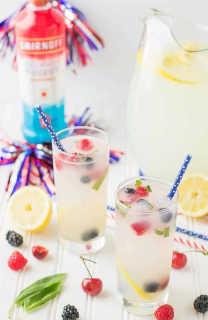 Refreshing and delicious, this Spiked Triple Berry Basil Lemonade is a perfect balance of sweet and tart. Smirnoff® Red, White and Berry vodka mixed with tart lemonade and fresh, sweet berries is the ultimate summertime cocktail! | Strawberry Blondie Kitchen