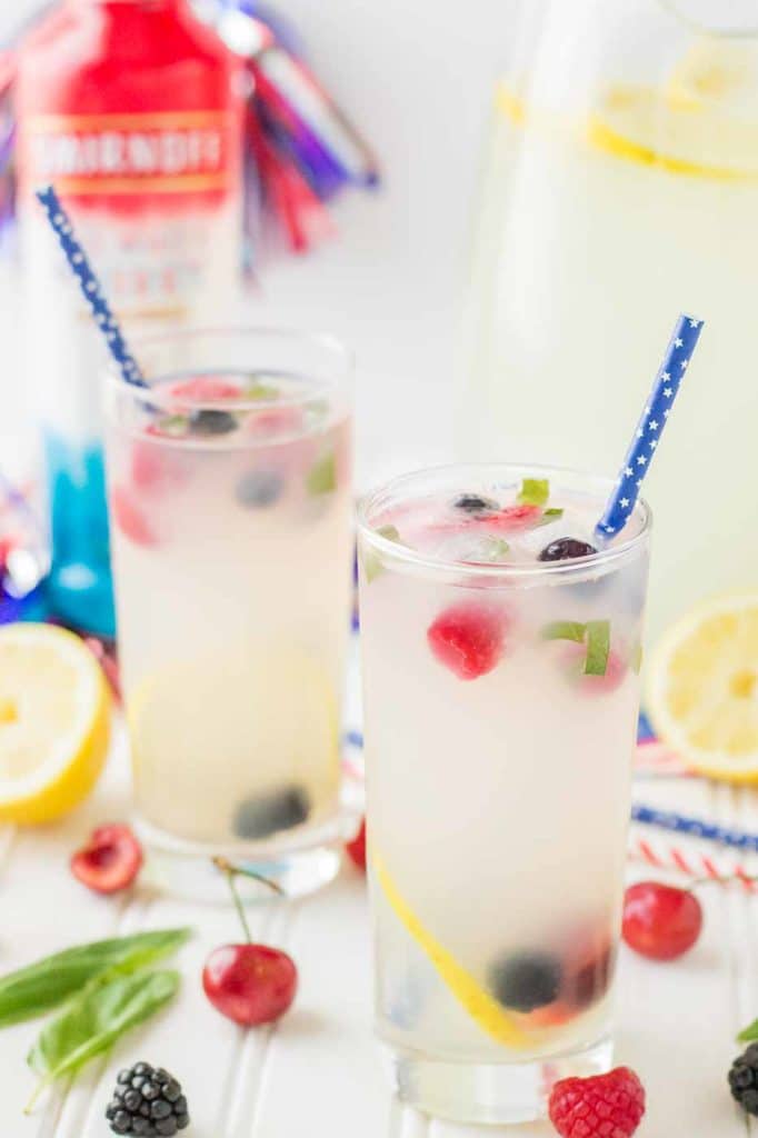 Refreshing and delicious, this Spiked Triple Berry Basil Lemonade is a perfect balance of sweet and tart. Smirnoff® Red, White and Berry vodka mixed with tart lemonade and fresh, sweet berries is the ultimate summertime cocktail! | Strawberry Blondie Kitchen