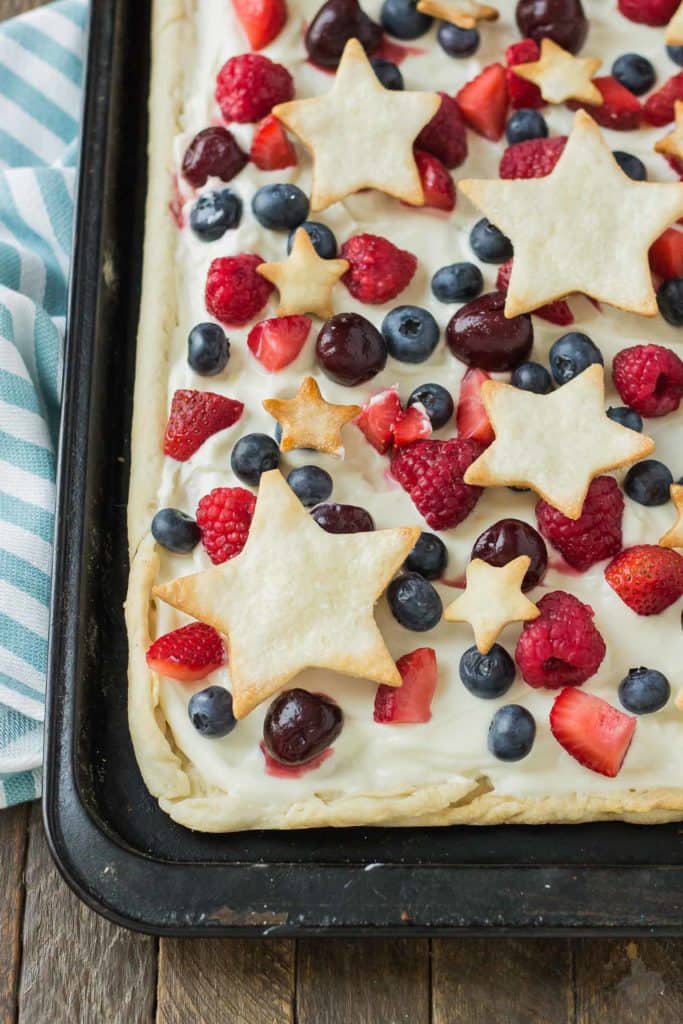 What is more Patriotic than a Star Spangled Berry Sheet Pan Pie?  It's an all American pie loaded with berries, citrus flavors and studded with pie stars.  A delicious addition to all your festive parties this year! | Strawberry Blondie Kitchen