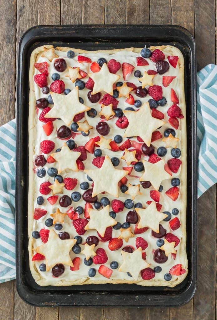 What is more Patriotic than a Star Spangled Berry Sheet Pan Pie?  It's an all American pie loaded with berries, citrus flavors and studded with pie stars.  A delicious addition to all your festive parties this year! | Strawberry Blondie Kitchen