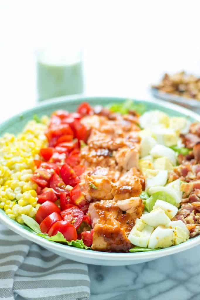 BBQ salmon cobb salad with Avocado Ranch Dressing is bursting with flavors to savor summer! Topped with a delicious crunch from ranch flavored chickpeas it's sure to be your next favorite salad! | Strawberry Blondie Kitchen