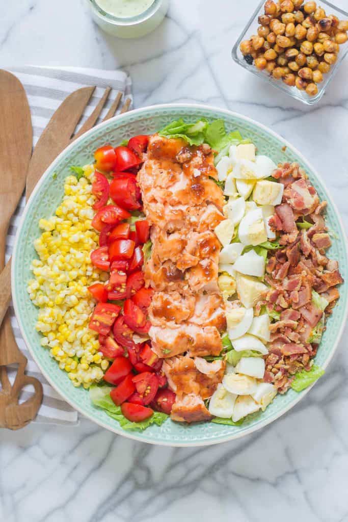 BBQ salmon cobb salad with Avocado Ranch Dressing is bursting with flavors to savor summer! Topped with a delicious crunch from ranch flavored chickpeas it's sure to be your next favorite salad! | Strawberry Blondie Kitchen