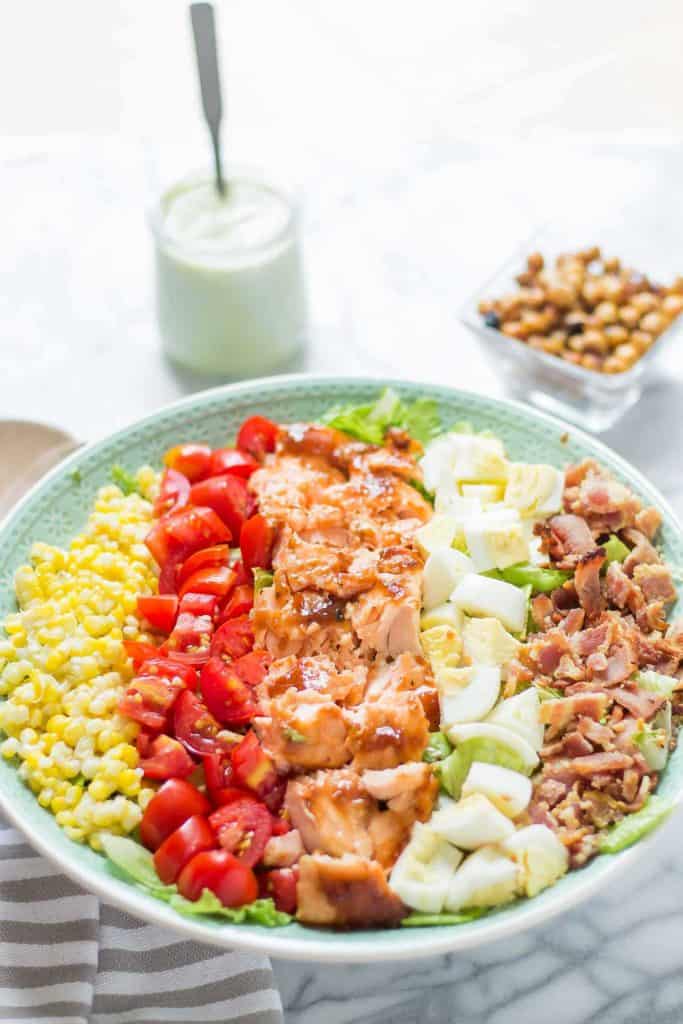 BBQ salmon cobb salad with Avocado Ranch Dressing is bursting with flavors to savor summer! Topped with a delicious crunch from ranch flavored chickpeas it's sure to be your next favorite salad! | Strawberry Blondie Kitchen