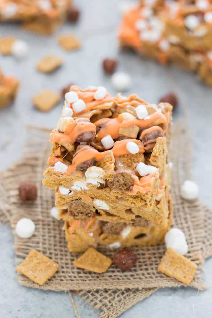 The classic crispy treat you love, turned into a Fall favorite.  These Pumpkin Spice S'mores Bars combine S’mores cereal, warm pumpkin spice seasoning and a delightful drizzle of chocolate and mini marshmallows. | Strawberry Blondie Kitchen