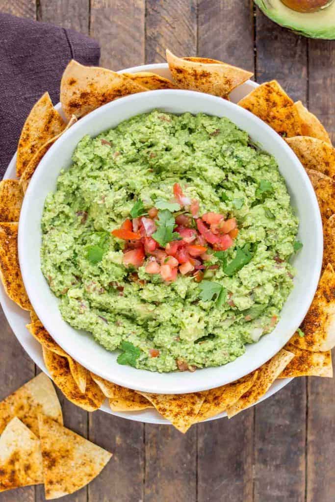 All the flavors you love of guacamole with an added boost of protein and fiber make this Edamame Guacamole super flavorful and a good for you dip. Paired with homemade smoky tortilla chips and you've got one delicious snack. | Strawberry Blondie Kitchen