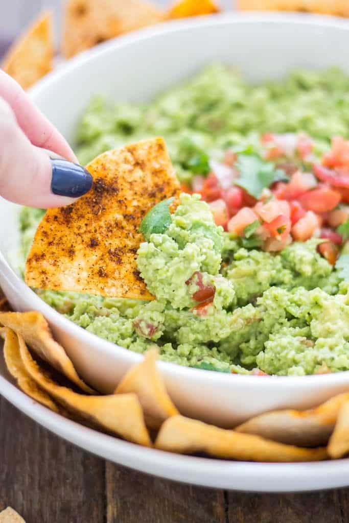 All the flavors you love of guacamole with an added boost of protein and fiber make this Edamame Guacamole super flavorful and a good for you dip. Paired with homemade smoky tortilla chips and you've got one delicious snack. | Strawberry Blondie Kitchen