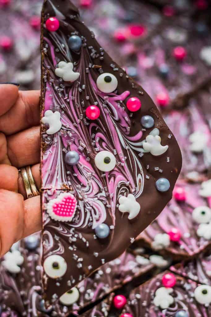 Super pretty and sparkly Halloween colors such as pink, silver and black make this Pink-O-Ween Candy Bark fun and creative.  Share it with the pink lover in your life! ? | Strawberry Blondie Kitchen