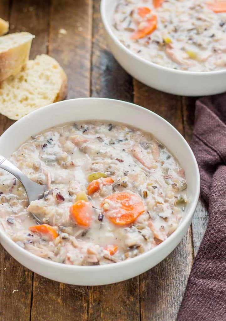 Creamy, delicious and pure comfort food, this healthy Crockpot Chicken and Wild Rice Soup comes together quickly thanks to your slow cooker.  Serve it tonight with some bread for dunking! | Strawberry Blondie Kitchen