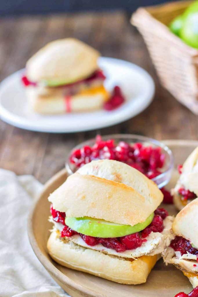 Crispy rolls, smoky turkey and cheese, with tart apples and sweet cranberry sauce come together harmoniously to create these Turkey Cheddar Cran Apple Sliders which are perfect for Thanksgiving leftovers. | Strawberry Blondie Kitchen