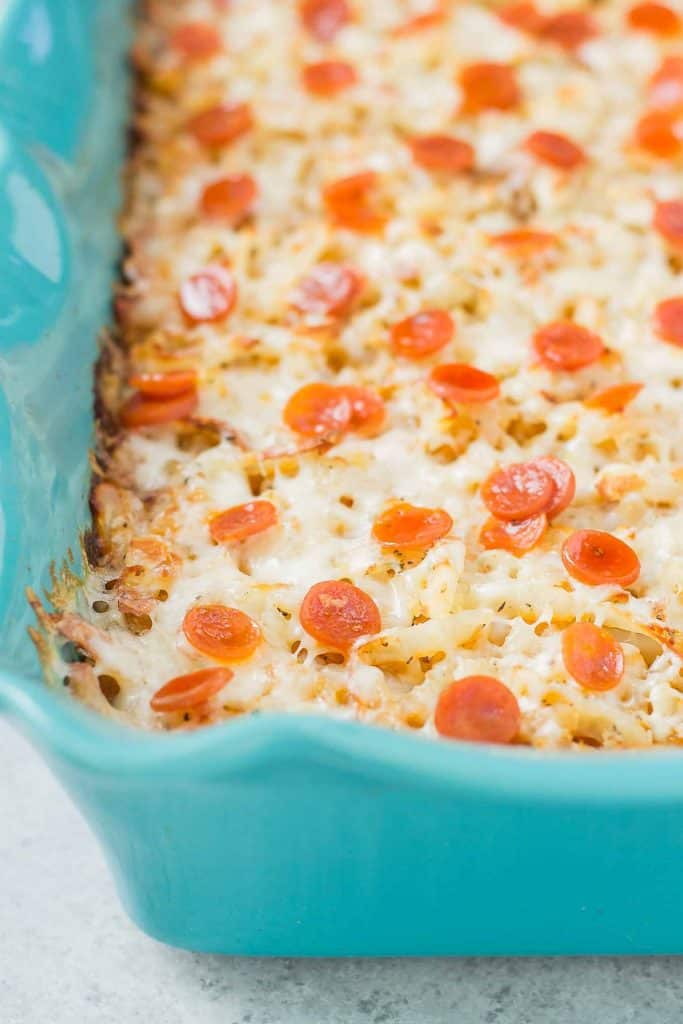 An awesome twist on a classic, this Pizza Shepherd's Pie combines sausage, pepperoni, cheese and hash brown potatoes to give you a hearty casserole worth devouring. | Strawberry Blondie Kitchen