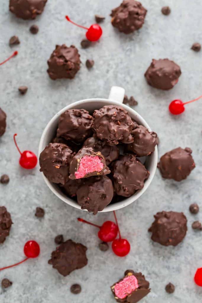 Cherry Mash Truffles in a mug surrounded by cherries and candy