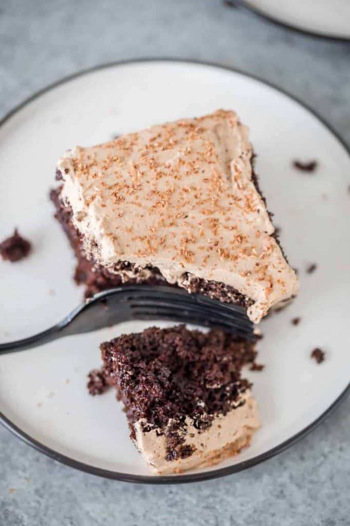 A slice of Irish Cream Poke Cake with a bite out of it