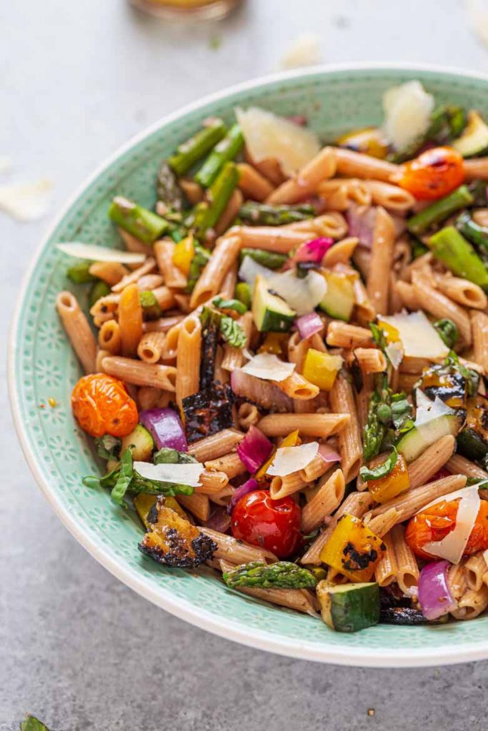 Garnish grilled vegetable pasta salad with chopped basil and shaved Parmesan cheese