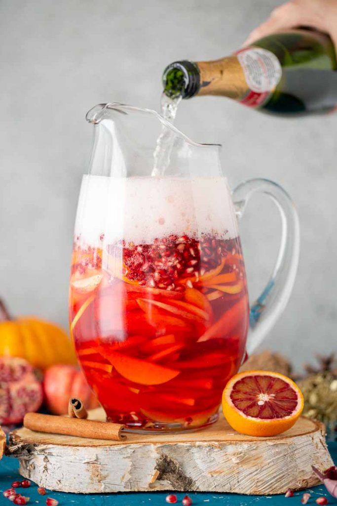 Pour champagne into pitcher for Blood Orange Party Punch