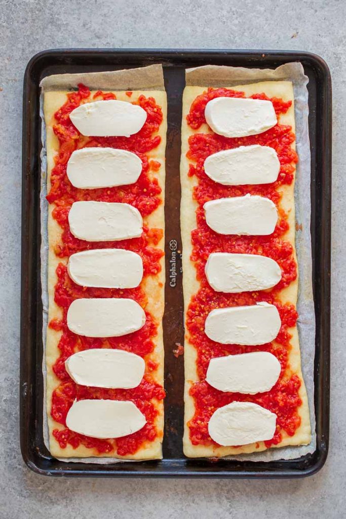 Place fresh mozzarella on top of crushed tomatoes on pizza crust