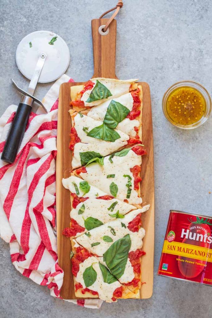 This Easy Margherita Flatbread Recipe is ready in under 20 minutes and thanks to Hunt's San Marzano style tomatoes, it's the freshest flatbread you'll get this side of Italy!