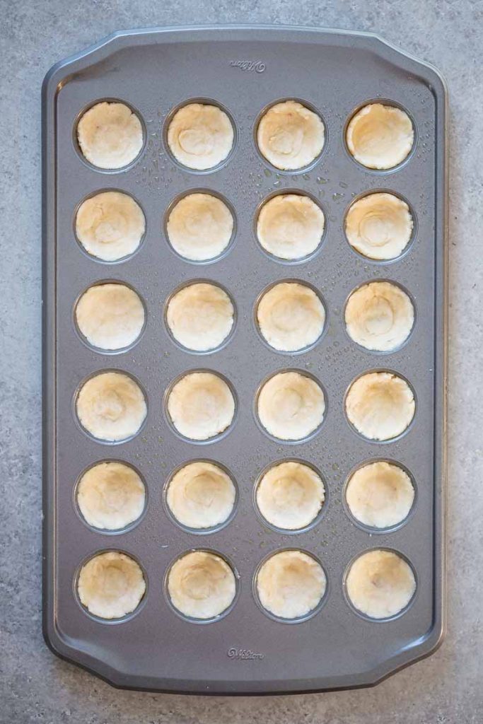 press pecan tassie dough into the well of a mini muffin tin