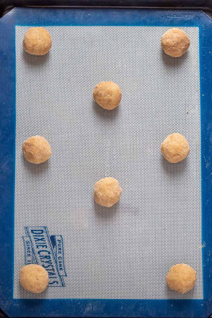 rolled Balls of snickerdoodle cookie dough on a cookie sheet ready to bake