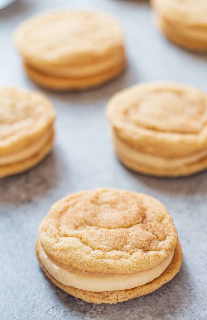 Snickerdoodle cookies sandwiched together with caramel cream cheese frosting