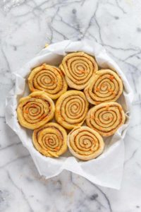Carrot cake cinnamon rolls in prepared pan ready for proofing.