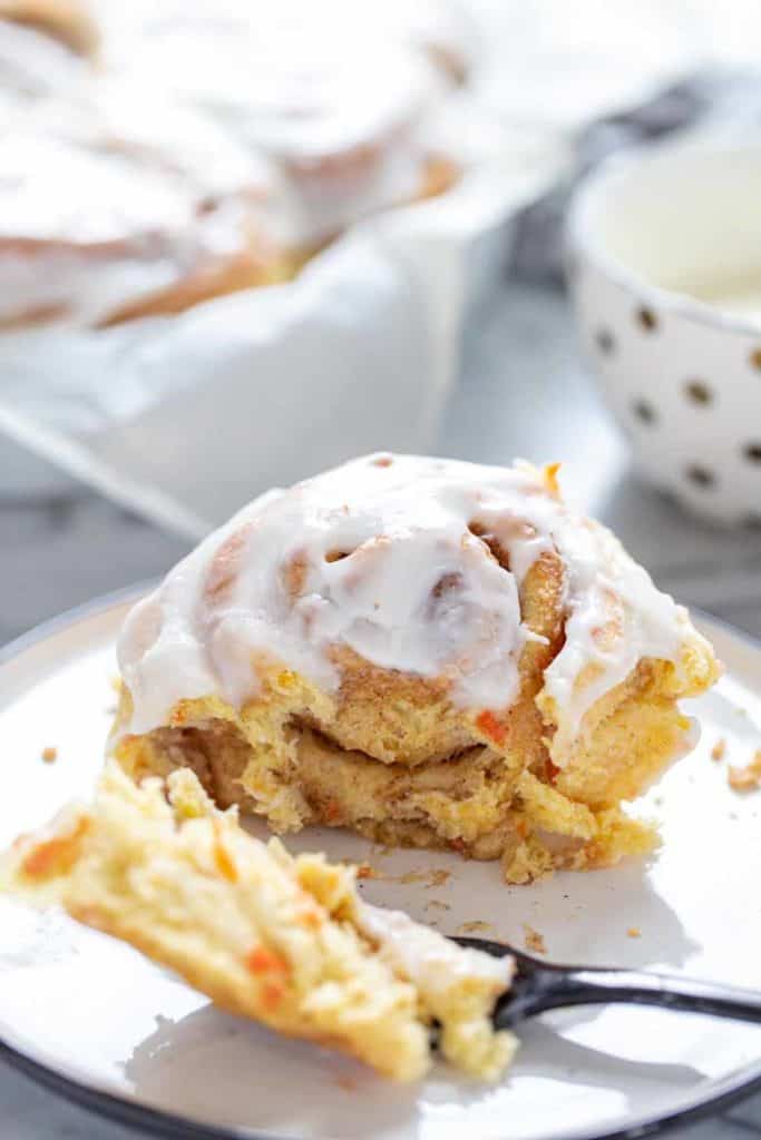 single shot of Carrot Cake Cinnamon Rolls with Cream Cheese Icing with a fork 