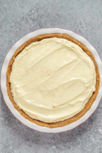 layers of bananas, pudding and whipped topping in pie pan