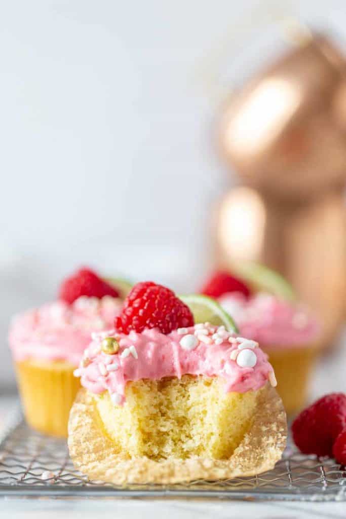 Raspberry Moscow Mule Cupcake with raspberry buttercream with single bite taken.