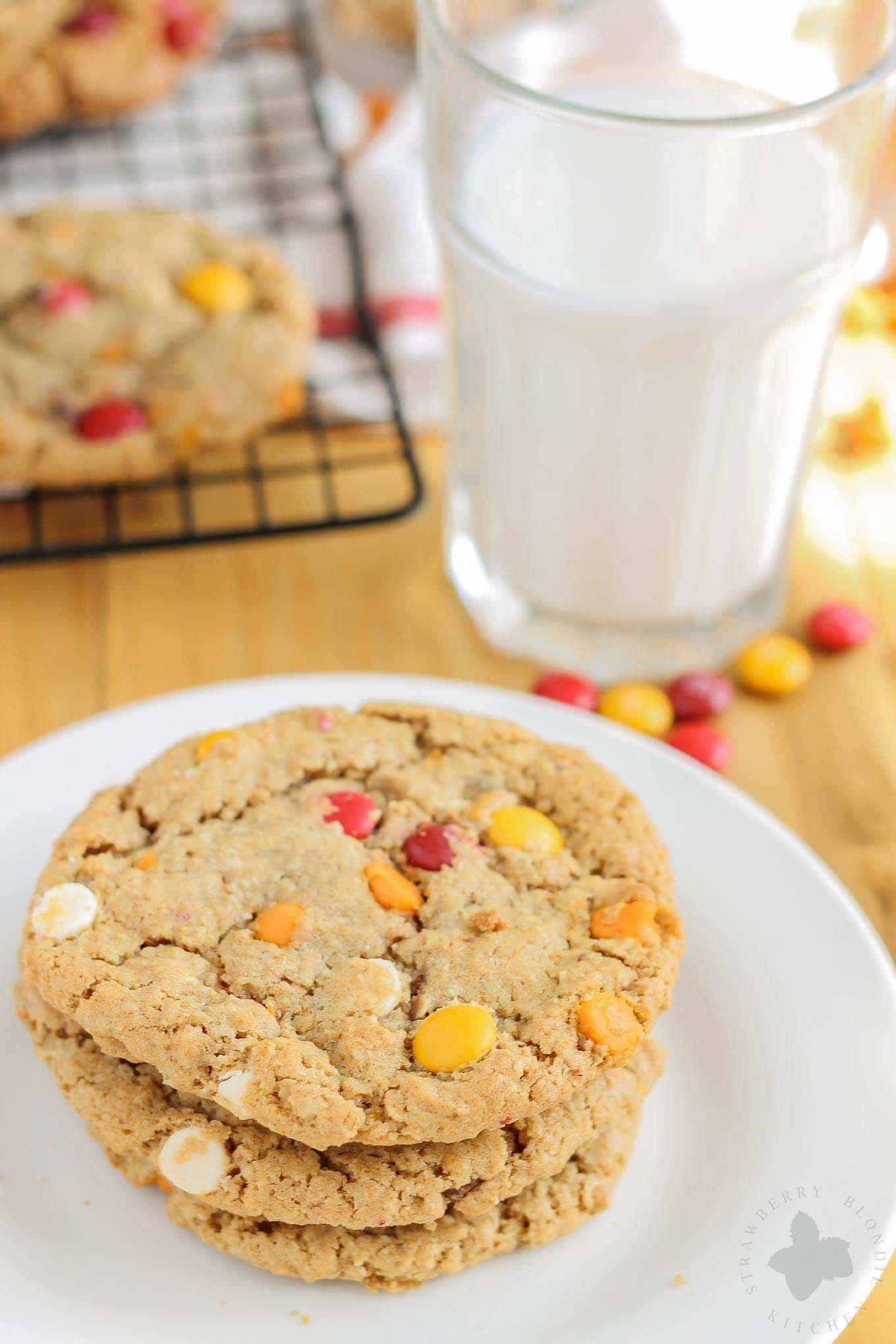 Monster cookies taken up a notch with the flavors of Autumn are both delicious and festive. Peanut butter mixed with pumpkin pie spice, white chocolate and pumpkin spice flavored chips and fall colored m & m's make these autumn monster cookies the perfect treat to serve all season long! | Strawberry Blondie Kitchen