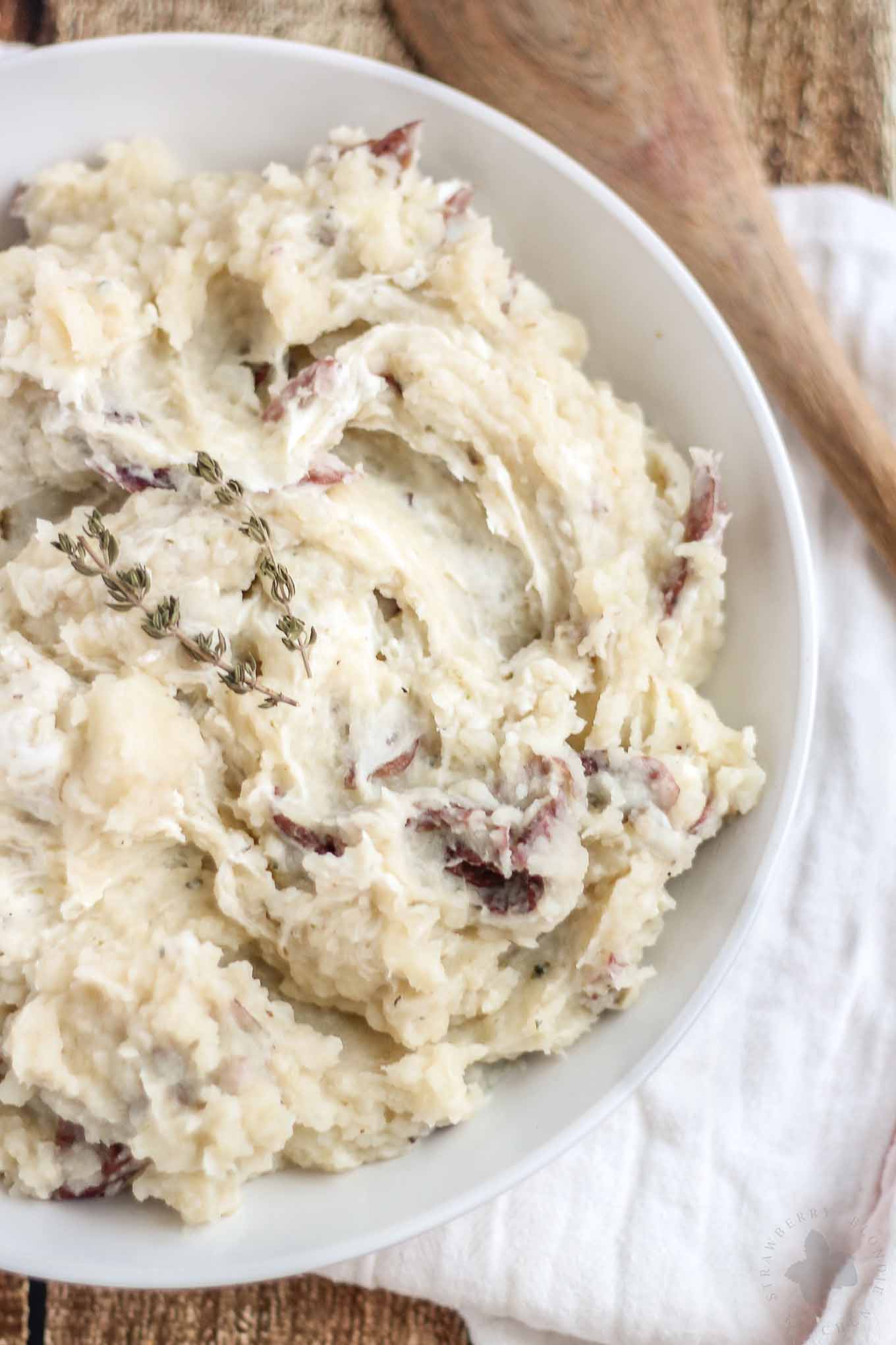 Free up space in your oven this holiday season with these Slow Cooker Goat Cheese Mashed Potatoes. They're tangy and full of garlic flavor from the herb goat cheese, fluffy and irresistibly delicious. They're sure to have your guests going back for seconds! | Strawberry Blondie Kitchen