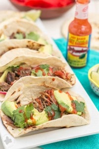 Tender, spicy, moist and juicy these Slow Cooker Spicy Pork Carnitas are perfect for the BIG GAME! Place on top of a tortilla with fresh ingredients, piled high on nachos or sandwiched between bread, no matter how you serve them, you've got a crowd pleaser perfect for game day, dinner or a fiesta! | Strawberry Blondie Kitchen