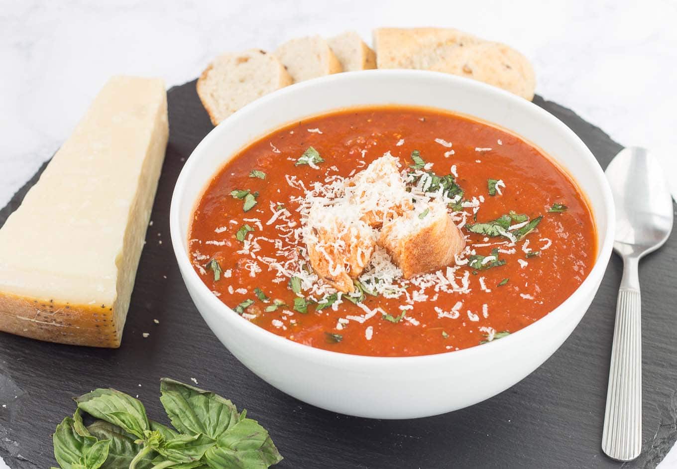 Garden vegetables are roasted to perfection and then placed in the slow cooker to simmer until tender making this Slow Cooker Roasted Red Pepper and Tomato Soup delicious and comforting. Top with freshly grated parmesan cheese and basil and serve a chunk of hearty bread on the side for the perfect weeknight dinner. | Strawberry Blondie Kitchen