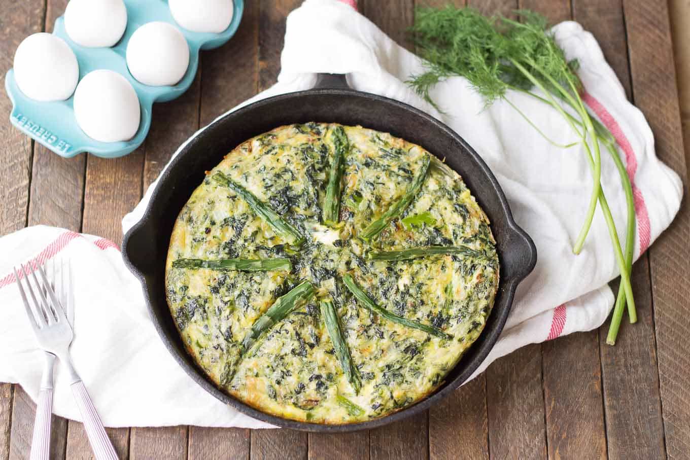Bursting with springtime flavors, this Asparagus and Spinach Frittata is the perfect dish to wake up to in the morning. Fresh asparagus, spinach and tangy goat cheese pair nicely to give you a healthy balanced breakfast, snack or meal any time | Strawberry Blondie Kitchen