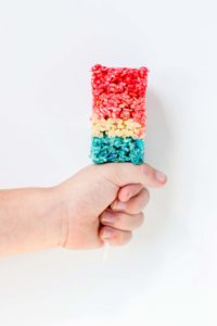 Reminiscent of the classic bomb pop, with much less mess, these Patriotic Crispy Treats are not your ordinary dessert. They’re layers of flavors with strawberry, vanilla and blue raspberry. A fun, new and Patriotic twist on everyone's favorite past time treat. Perfect addition to your next American party! | Strawberry Blondie Kitchen