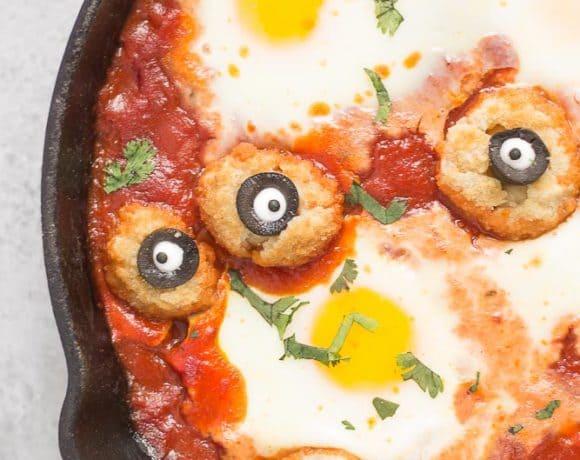 Eggs are baked in a tomato sauce and then breaded mushrooms with sliced black olives, made to looks like eyes, are nestled alongside to create Eyeballs in Purgatory. A festive Halloween meal sure to please the entire family! | Strawberry Blondie Kitchen