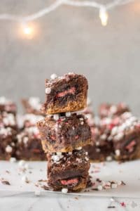 These Peppermint Hot Chocolate Brookies feature a layer of chocolate chip cookies, peppermint sandwich cookies, a layer of brownies and then topped with dark chocolate, crushed peppermint and mini marshmallows. | Strawberry Blondie Kitchen