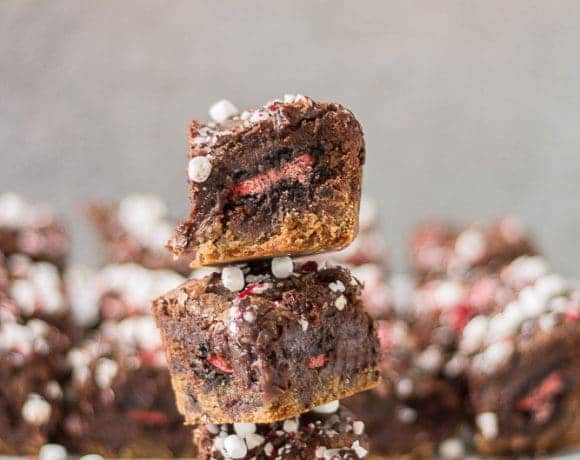 These Peppermint Hot Chocolate Brookies feature a layer of chocolate chip cookies, peppermint sandwich cookies, a layer of brownies and then topped with dark chocolate, crushed peppermint and mini marshmallows. | Strawberry Blondie Kitchen