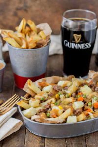 Crispy fries piled high with beef and mixed vegetables, smothered in Guinness gravy and topped with cheese curds make for one awesome Shepherd's Pie Poutine. | Strawberry Blondie Kitchen