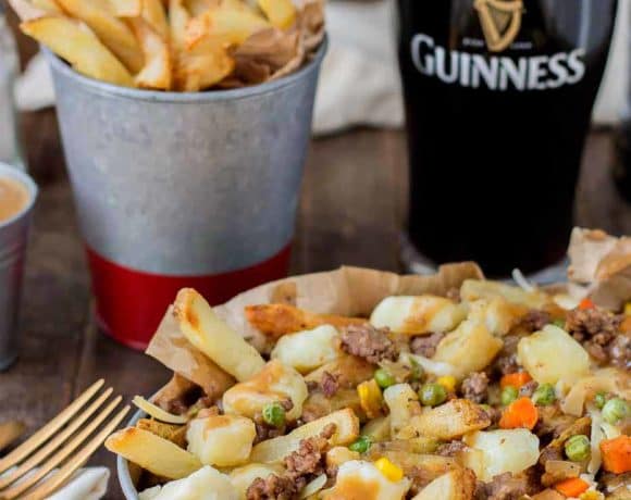 Crispy fries piled high with beef and mixed vegetables, smothered in Guinness gravy and topped with cheese curds make for one awesome Shepherd's Pie Poutine. | Strawberry Blondie Kitchen