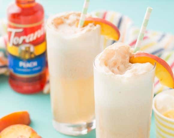 With 4 ingredients, your only 5 minutes away from a fun and delicious Peaches and Cream Soda.  Peach syrup, cream, ice cream and club soda make this Peaches and Cream Soda delightful and the perfect summer sipper! Strawberry Blondie Kitchen