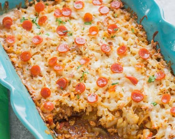 An awesome twist on a classic, this Pizza Shepherd's Pie combines sausage, pepperoni, cheese and hash brown potatoes to give you a hearty casserole worth devouring. | Strawberry Blondie Kitchen