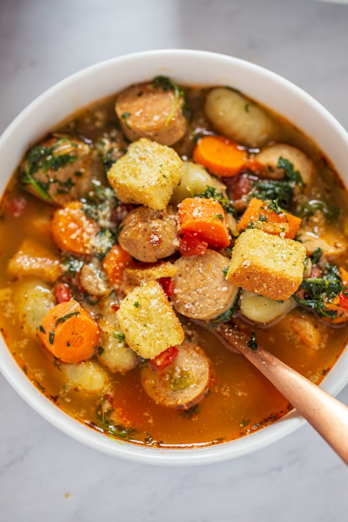 close up photography shot of Italian Chicken Gnocchi Soup piled high in a bowl 