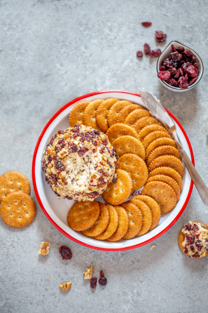 Cranberry Orange Pecan Cheeseball on a platter with crackers
