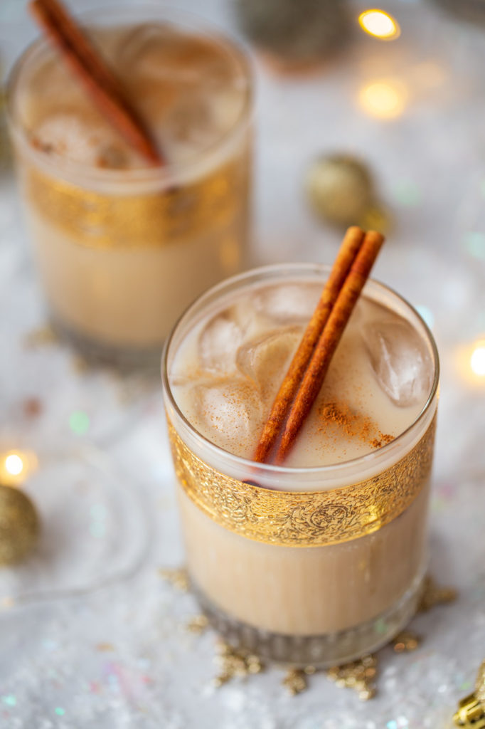 overhead shot of oatmeal cookie white russian cocktail recipe with cinnamon sticks in gold leaf rocks glasses
