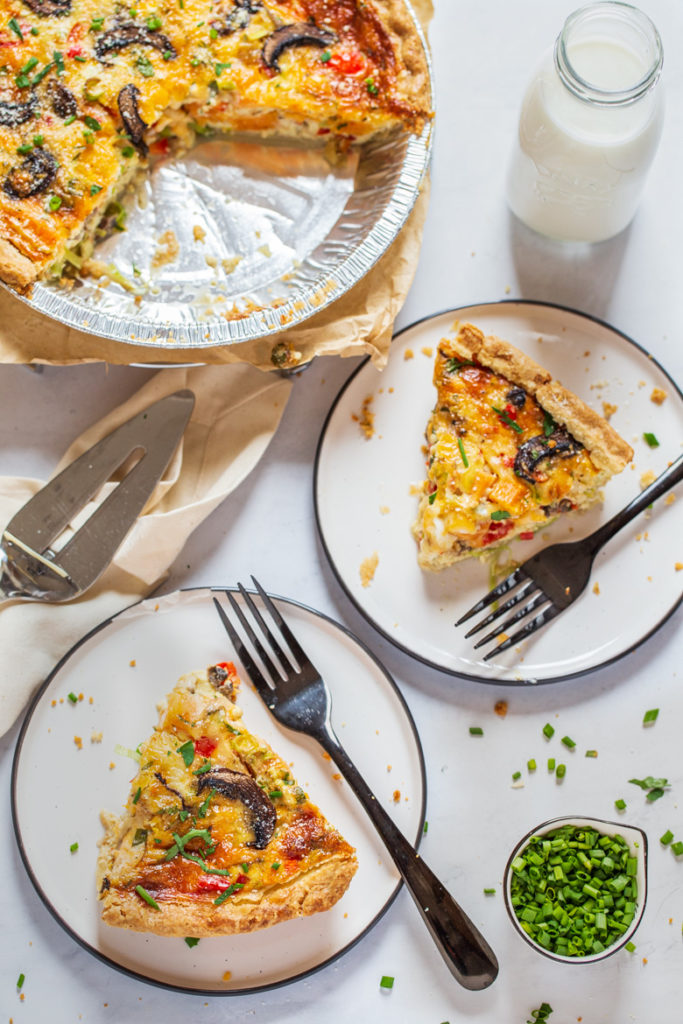 Slices of vegetable quiche on a plate with forks