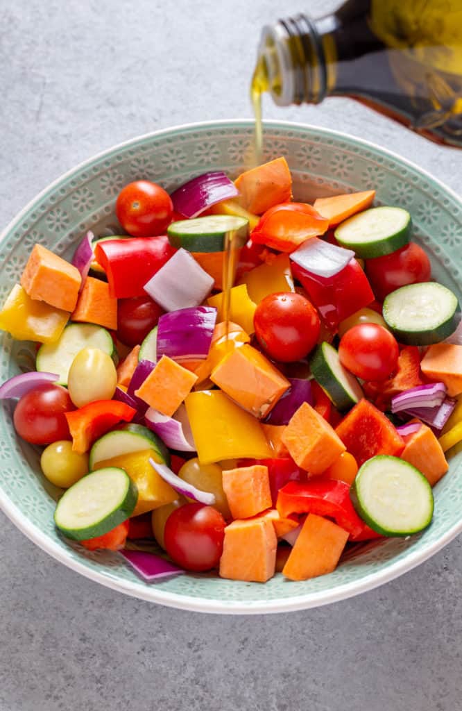 Bowl full of chopped vegetables with a drizzle of extra virgin olilve oil