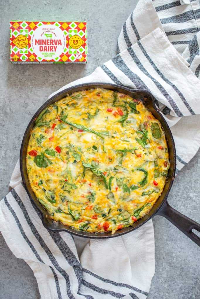 Garden Herb Frittata in a cast iron pan with Minerva Dairy garlic herb butter