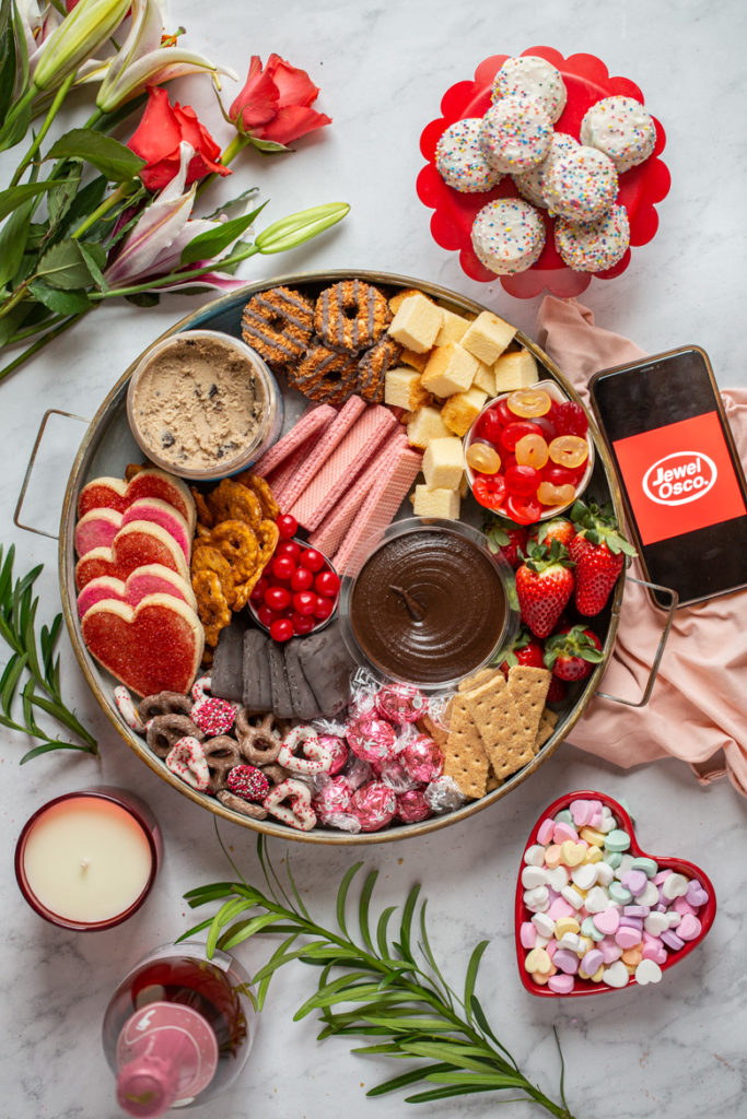 Round tray of cookies, candy, chocolate, edible cookie dough, tea cakes and strawberries for Valentine's day dessert board available at Jewel Osco
